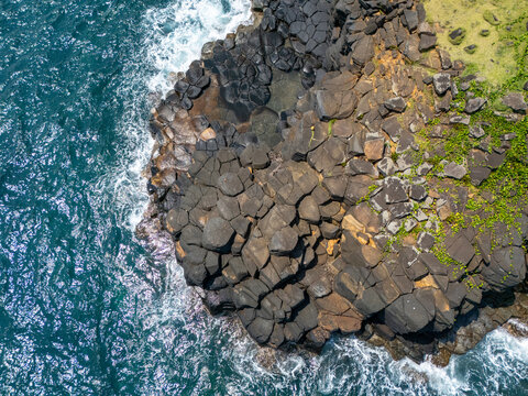 Unique hexagonal basalt rock formations on the coast of São Tomé, shaped by ancient volcanic activity.
