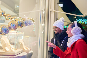 Young couple window shopping jewelry at christmas time