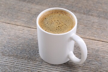 Aromatic coffee in cup on wooden table, closeup. Mockup for design