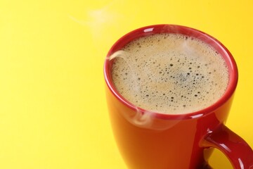 Aromatic coffee in cup on yellow background, closeup. Space for text