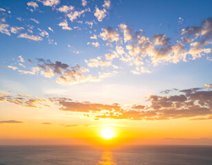 Fototapeta premium Beautiful sunrise over the ocean with clouds and blue sky stock photo