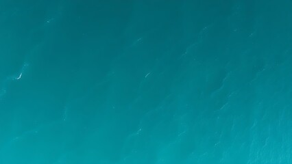 Aerial view of a turquoise coastline with abstract wave patterns and blue tones.
