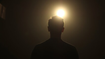 A silhouette in dim light with a faint glow, creating a mysterious and atmospheric mood.