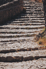Ancient stone steps wind through a historic landscape under a bright sun, inviting explorers to discover the secrets of the past