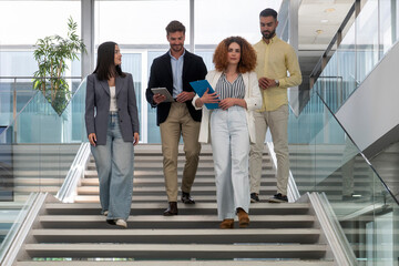 Businesspeople walking downstairs in modern office building