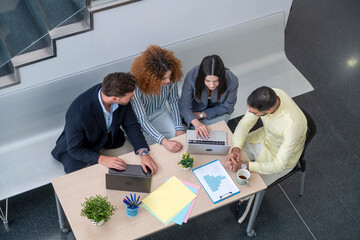 Business people working together around table using laptop in modern office
