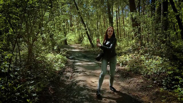 Terrified woman defending with stick against serial killer in forest. Scared female fighting back with branch against maniac on woodland path. Frightened lady resisting attacker with tree limb in