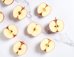 A vibrant flat lay of fresh red apple halves creating a natural pattern on an elegant white marble countertop