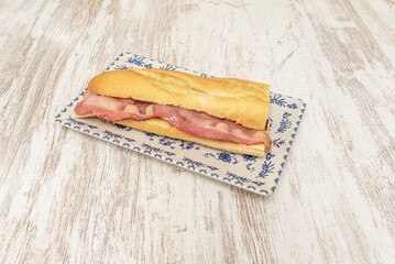 Classic extra-crispy bacon sandwich with melted Swiss cheese, presented on buttered toasted bread