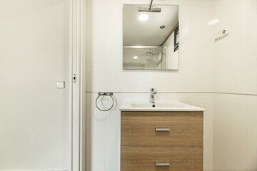 Contemporary design in a compact bathroom with a floating oak vanity unit and integrated storage, ideal for small spaces