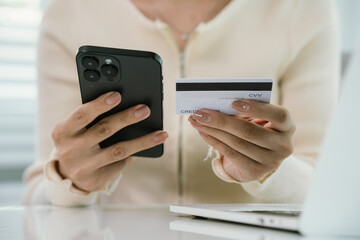 A person holds a credit card while typing on a laptop, symbolizing online shopping, e-commerce, digital payments, secure banking, financial transactions, consumer lifestyle, and modern business techno