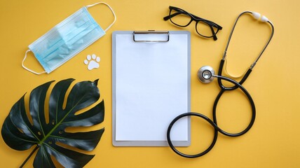 Veterinary appointment reminder with stethoscope and face mask on yellow background for pet health awareness