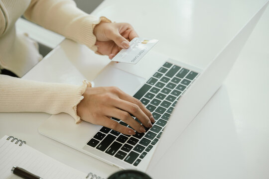 A businesswoman uses her laptop for online banking and e-commerce, managing payments, shopping, and financial transactions in cyberspace, reflecting modern technology, digital security, investment, an