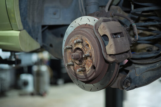 Car rotor with bolts, brake pad, and calipers