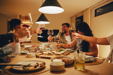 Friends enjoying dinner and wine together in a warm indoor scene