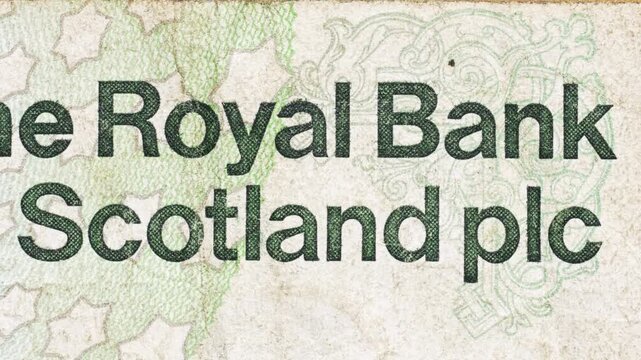 Macro pan across Royal Bank of Scotland text on Scottish pound banknote