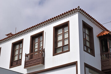Modern White Painted Mediterranean Style House with Wooden Balcony seen from Below 