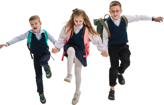 Schoolchildren running hand in hand in uniforms with backpacks on transparent background. Concept of joy, childhood, education, teamwork, friendship, and active learning lifestyle.