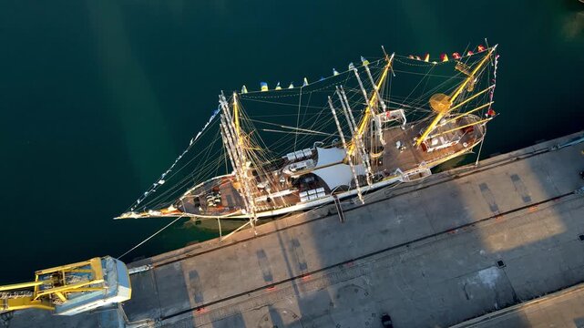 Tall sailing ship Mircea, the Romanian Navy&rsquo;s training vessel, docked in the port of Durr&euml;s, Albania at sunset. Historic three-masted barque with full rigging. Drone aerial view.