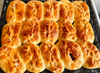 Freshly baked golden pies with filling on a baking tray, homemade traditional pastry.