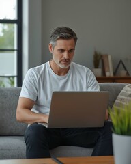Focused man working on laptop at home, casual and professional