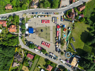 Drone view of Lezajsk City Days celebration with concerts, stage lights, illumination, attractions for children and crowds enjoying music and summer festivities. City days celebration in Poland.