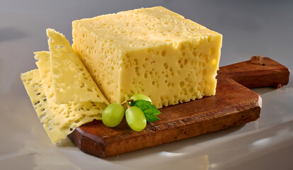 Frankendamer mit Scheiben auf rustikalem Holzbrett, Käsescheiben, Käseblock, Schnittkäse, 