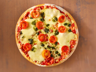 Pizza Topshot mit Kirschtomaten und Mozzarella auf Holzfond, Margherita, Tomaten halbiert, isoliert, Pesto, 