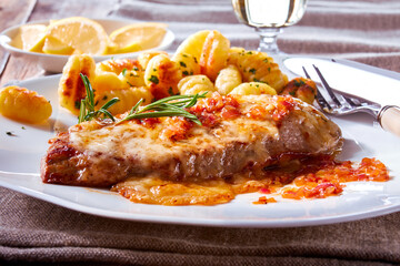 Schnitzel mit Gnocchi auf gedecktem Tisch und weissem Porzellanteller, gedeckter Tisch, Sauce, 