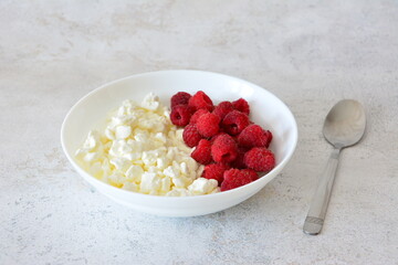 Cottage Cheese and Raspberries in white bowl A Healthy Breakfast with organic berries