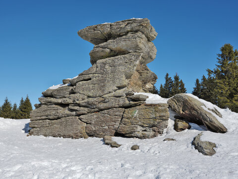 Medium format photo of heavy stone blocks on Austrian summit Teufelstein against blue winter sky. This mystical rock formation consists of three individual rock blocks.