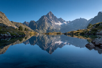 High mountain peak reflected in a calm alpine lake, perfectly symmetrical composition