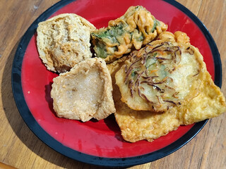 Gorengan, traditional Indonesian street snack consisting of tofu, fried banana, bakwan, tempe mendoan, etc. Served with green chilies.