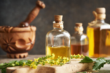 Herbal tincture with fresh blooming agrimony plant on a table