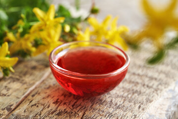 Red oil made from St. John's wort flowers in a bowl