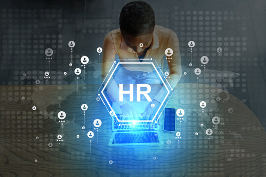 Professional preparing HR documents in an office setting using a laptop and virtual data visualizations - Powered by Adobe
