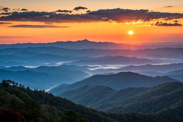 Obraz premium sunset over a mountain range with trees and clouds in the sky