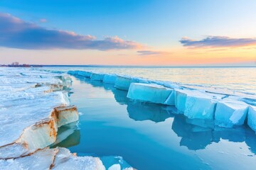 Frozen lake shore at sunset.  Tranquil ice formations, vibrant colors, calm water