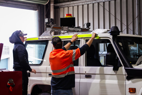 workmen in workshop adding reflective tape to complete fitout of mining fleet vehicle