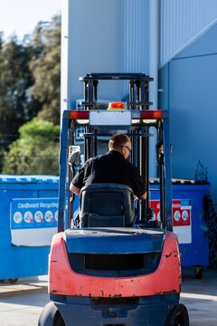 Forklift operator using machinery to move industrial bins around site