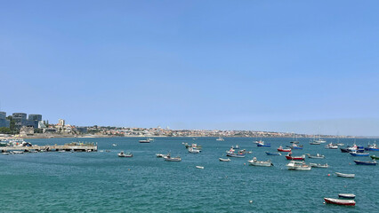 Numerous boats anchored in a blue calm sea under a clear sky