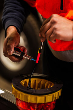 workman in high vis using blow torch to secure cables with heat shrink