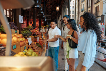 Tourists choosing fresh fruit at market stall in Spain