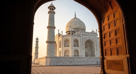 Fototapeta premium Taj Mahal glimpsed through an archway at sunrise