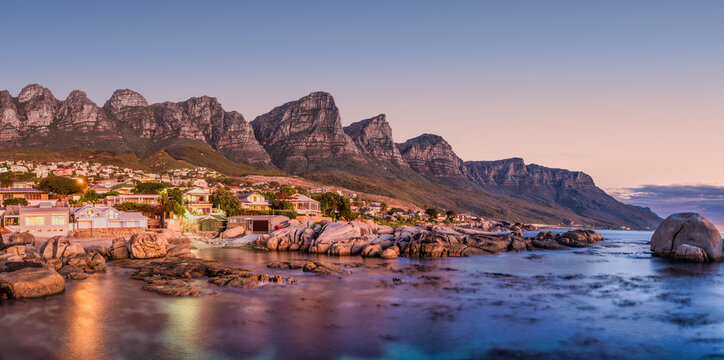 Panorama long exposure: Bakoven beach lights reflecting on turquoise water, Cape Town, South Africa