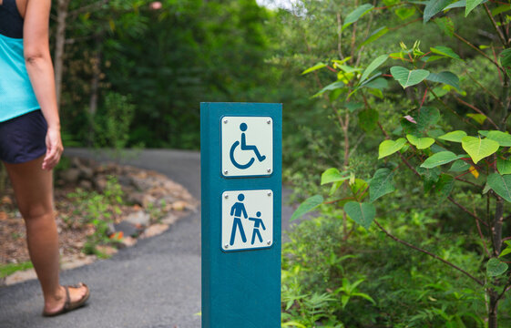 Woman walking past signage on a walking track