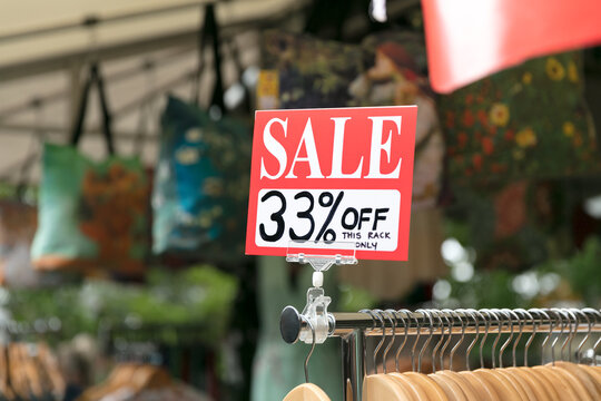 Outdoor sale sign on clothing rack at retail store