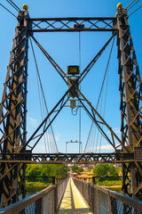 Fototapeta premium The Ticonic Footbridge, also known as the Two Cent Bridge, a historic 1903 suspension bridge over the Kennebec River, linking Waterville and Winslow in Kennebec County, Maine, USA