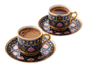 Two cups of coffee on matching saucers with a floral design and gold trim on a black background