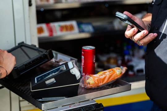 male worker on lunch break at industrial workplace purchasing food with tap and pay on phone